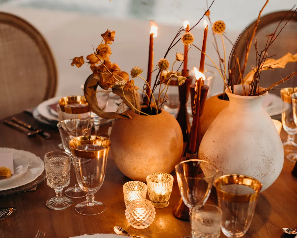 A wooden table topped with a vase filled with flowers, a still life by Louisa Puller, featured on pexels, aestheticism, rich color palette, photo taken with ektachrome, flickering light